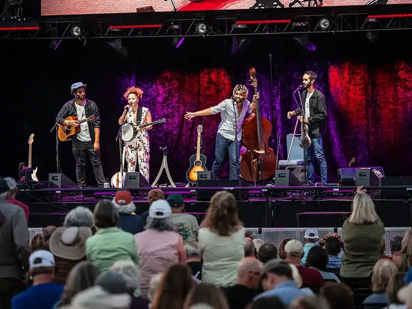 New Dangerfield band photo, performing on a stage with an audience in front of them.