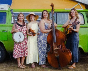 Hazel Project - Four women pose with ther instruments in front of a green truck.