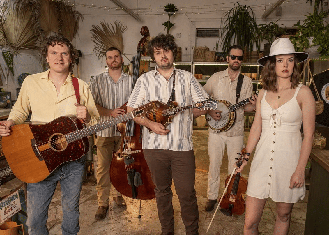 East Nash Grass photo of the band, holding instruments and smiling.