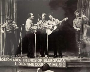 Black and white photo from the early 70s of Spider Bridge opening for Shendoah Cutups. Full bluegrass band is depicted on the Congregational Church stage.